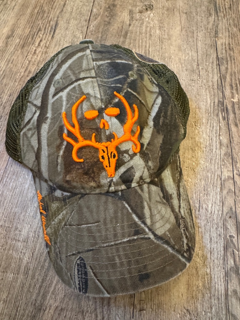 Camo Trucker Hat with Bright Orange Deer Skull Patch